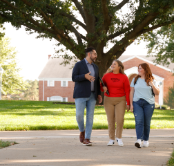 Students with administrator walking on campus